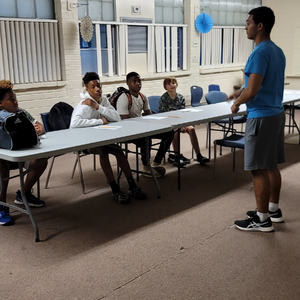 Photo of Grind Out student tutor in front of grind out students teaching